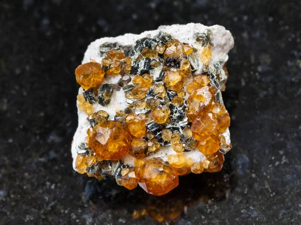 Сырые кристаллы спессартинного драгоценного камня на темной — стоковое фото