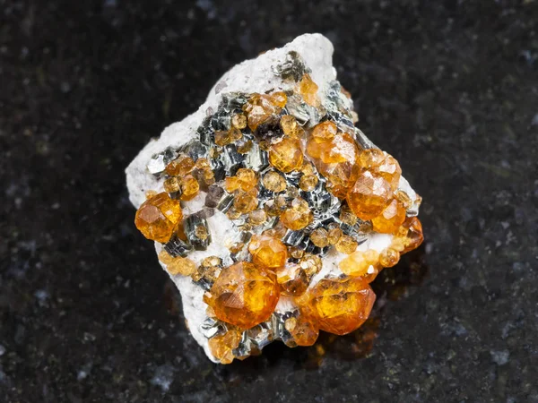 Kristaller av spessartine ädelsten på mörk — Stockfoto