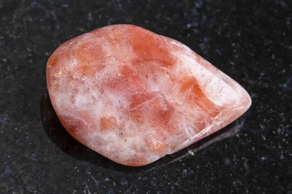 Πολύτιμος λίθος γυαλισμένο sunstone (heliolite) στο σκοτάδι — Φωτογραφία Αρχείου