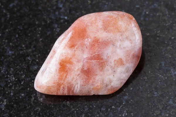 Tromlované sunstone (heliolite) drahokam na tmavé — Stock fotografie