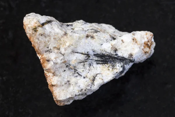 Black Ludwigite crystals in raw stone on dark — Stock Photo, Image