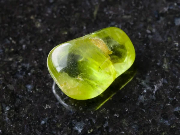 Piedra de peridoto pulido sobre fondo oscuro — Foto de Stock