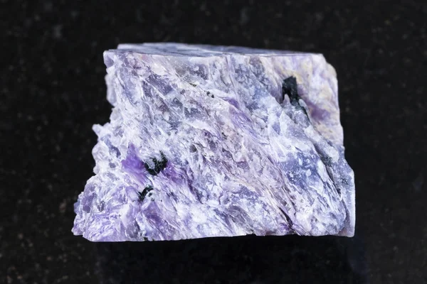 Raw charoite stone on dark background — Stock Photo, Image