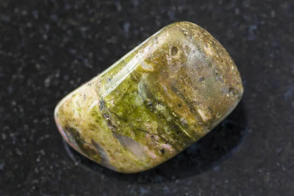 Piedra de gema unakite tumbled sobre fondo oscuro — Foto de Stock