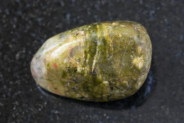 Piedra de gema unakite pulido sobre fondo oscuro — Foto de Stock