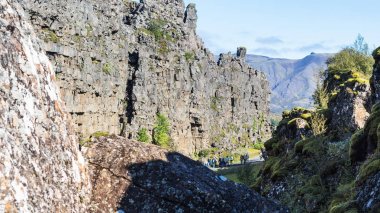 turistler Almannagja gorge kayalar arasında