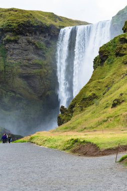 İzlanda'daki Skogafoss şelale yakın kişi