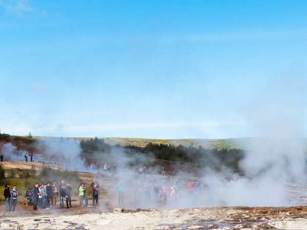 people wait eruption of geyser in Haukadalur