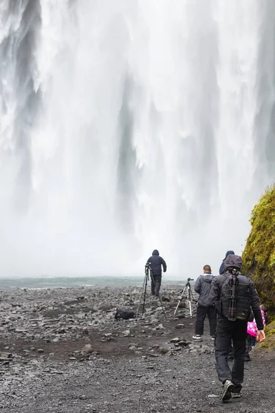 Skogafoss 폭포의 하단에 관광객 — 스톡 사진