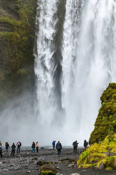 Turisté v blízkosti Skogafoss vodopád na Islandu — Stock fotografie