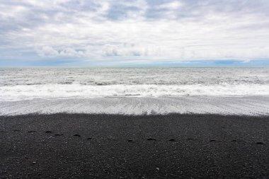 İzlanda'daki Reynisfjara siyah sahilde okyanus dalgaları