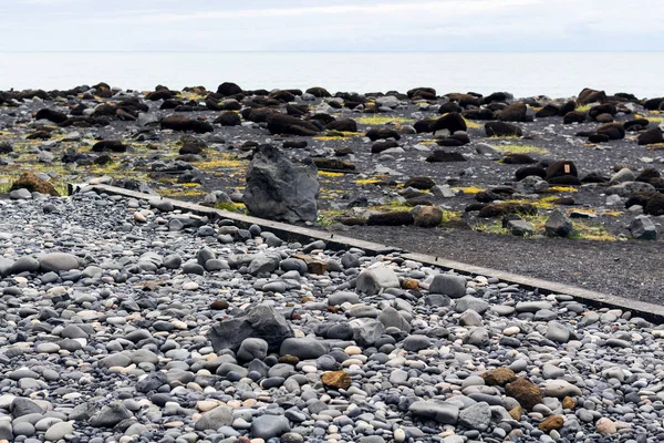 Guijarros en la playa de Reynisfjara en el pueblo de Vik — Foto de Stock