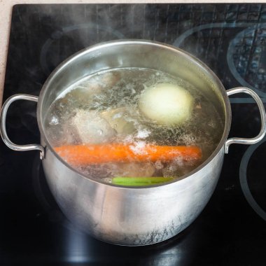 boiling meat broth in stockpot on ceramic cooker clipart