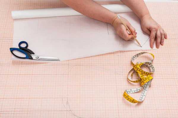 Tailor copies a clothing pattern on tracing paper — Stock Photo, Image