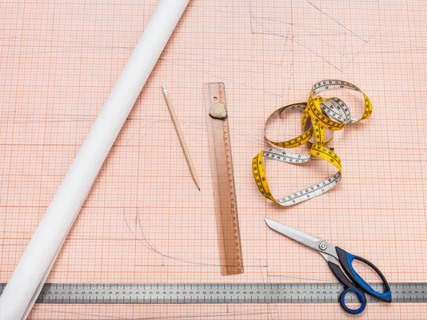 Items to draw a clothing pattern on graph paper — Stock Photo, Image