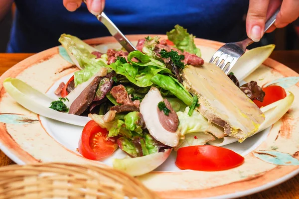 Besucher isst Salat mit normannischen Fleischvorspeisen — Stockfoto