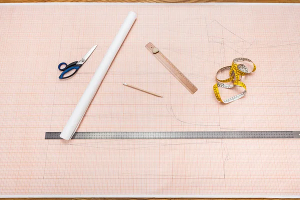 Verktyg för att rita ett kläder mönster på rutat papper — Stockfoto