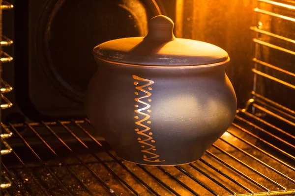 Gesloten keramische pot in verlichte elektrische oven — Stockfoto