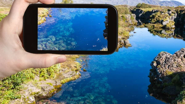 Turist fotografier vatten i Silfra earth spricka — Stockfoto