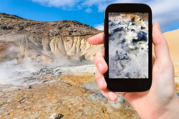 Tourist photographs mud acidic geyser in Iceland — Stock Photo, Image