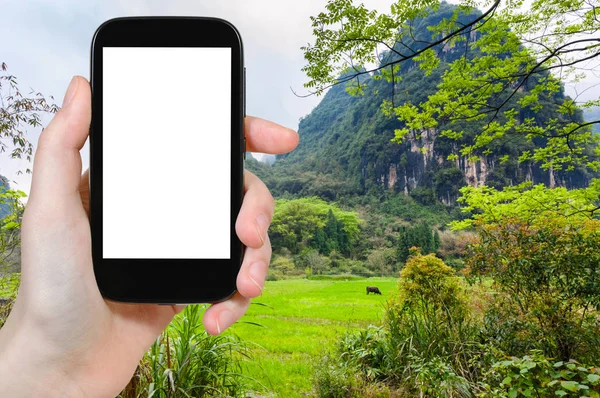 Tourist photographs green meadow in Yangshuo — Stock Photo, Image