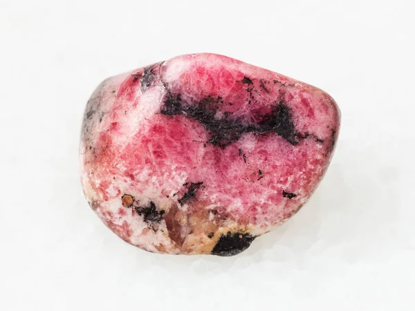 Piedra de gema de rodonita rosa pulida en blanco — Foto de Stock