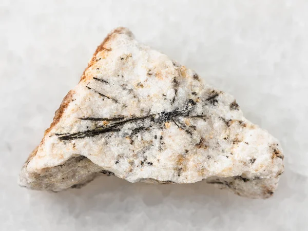 Черные кристаллы Людвигита в грубом камне на белом — стоковое фото