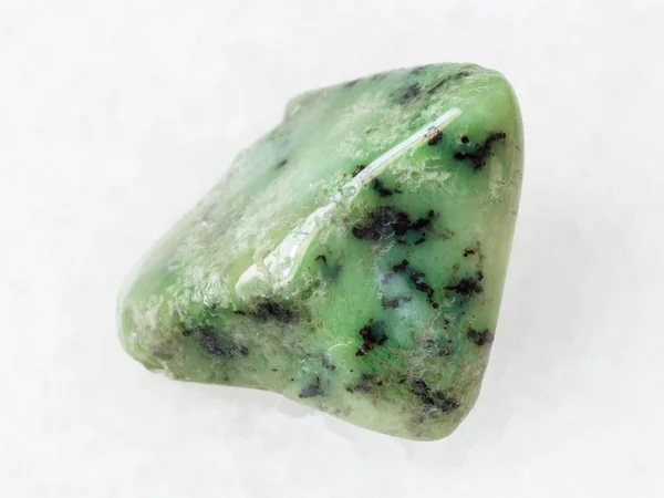 Grüner grobkörniger Edelstein auf weißem Grund — Stockfoto