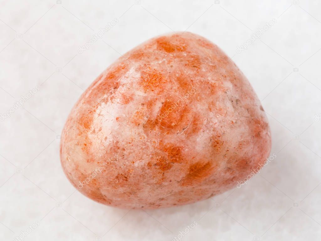 polished sunstone (heliolite) gem stone on white