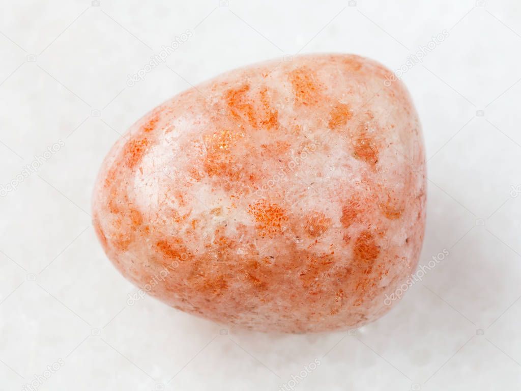 tumbled sunstone (heliolite) gem stone on white