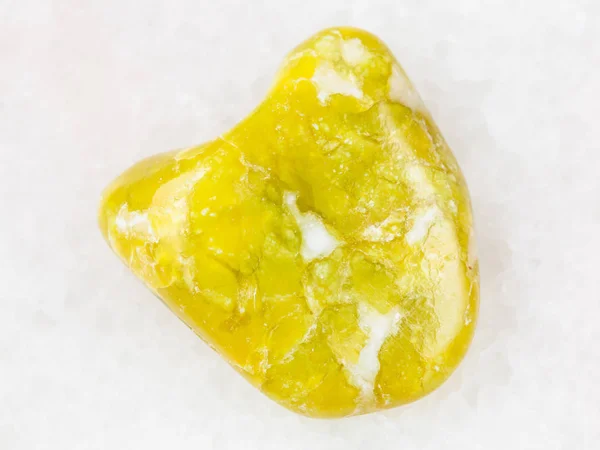Pierre précieuse de lézardite jaune poli sur blanc — Photo