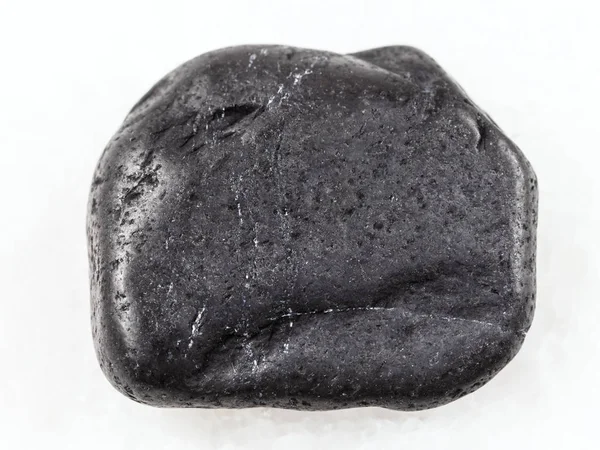 Галька шунгітського дорогоцінного каменю на білому мармурі — стокове фото