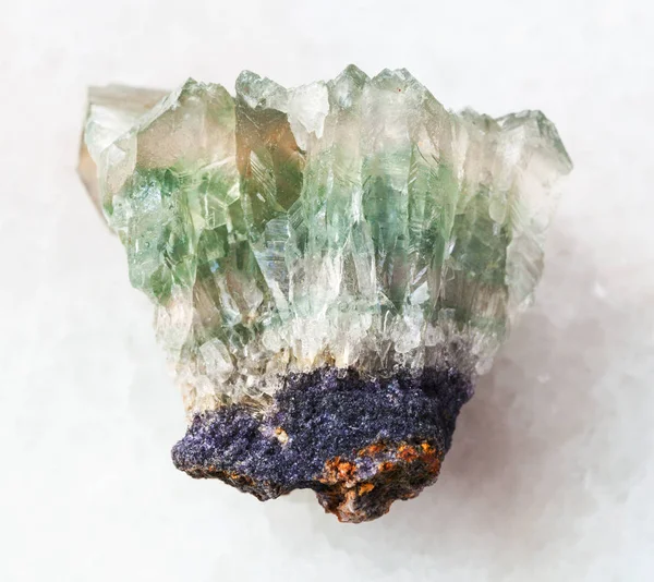 Piedra preciosa de fluorita cristalina cruda sobre mármol blanco —  Fotos de Stock