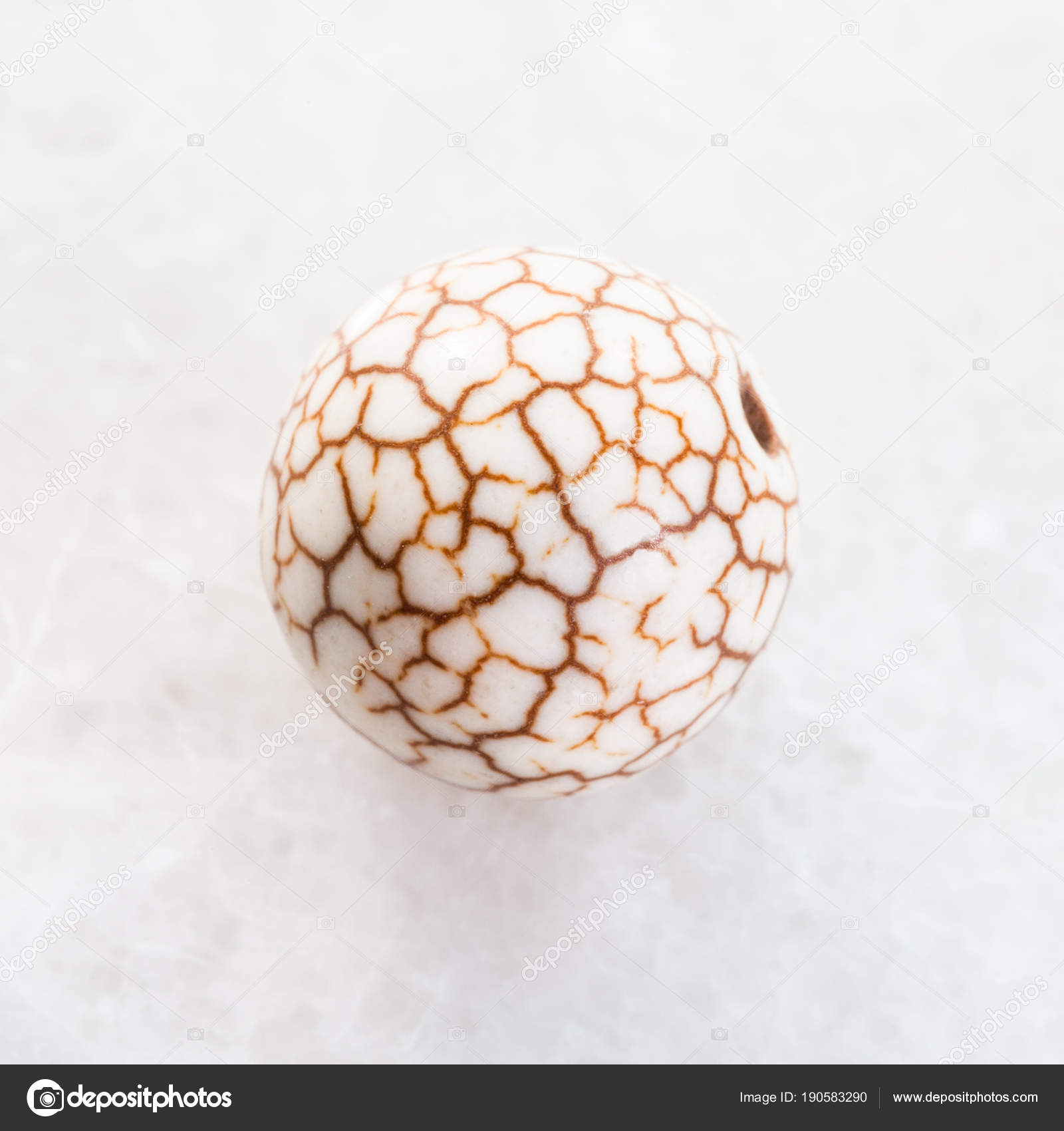 Bead from cracked Cacholong gemstone on white — Stock Photo