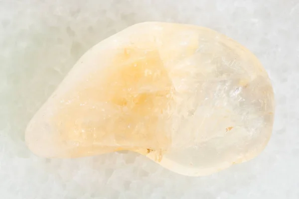 Trommelgelber Citrin-Edelstein auf weißem Marmor — Stockfoto