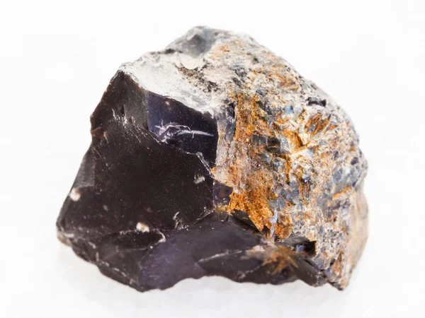 Rough black Flint stone on white marble — Stock Photo, Image