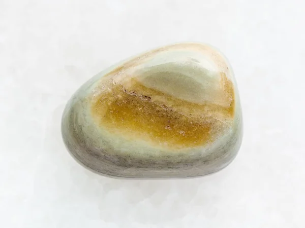 Polierter grauer Achat Edelstein auf weißem Marmor — Stockfoto