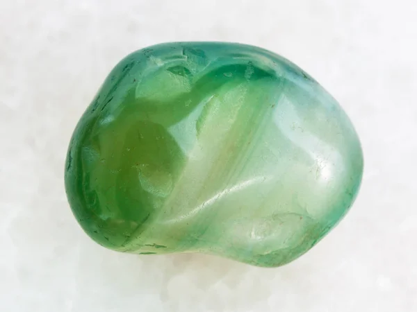 Polished green dyed agate gemstone on white marble — Stock Photo, Image