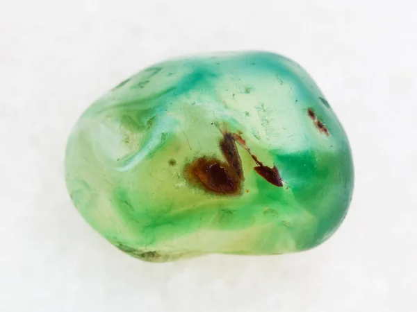 Trommelig grün gefärbter Achat-Edelstein auf weißem Marmor — Stockfoto