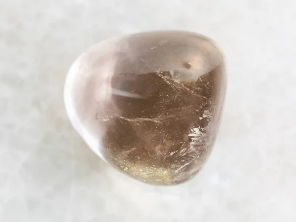 Piedra de gema de cuarzo ahumado pulido sobre mármol blanco — Foto de Stock