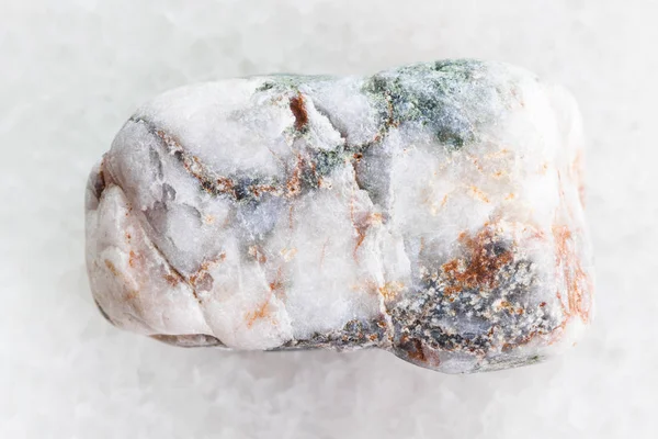 Tumbled marble pebble on white marble — Stock Photo, Image