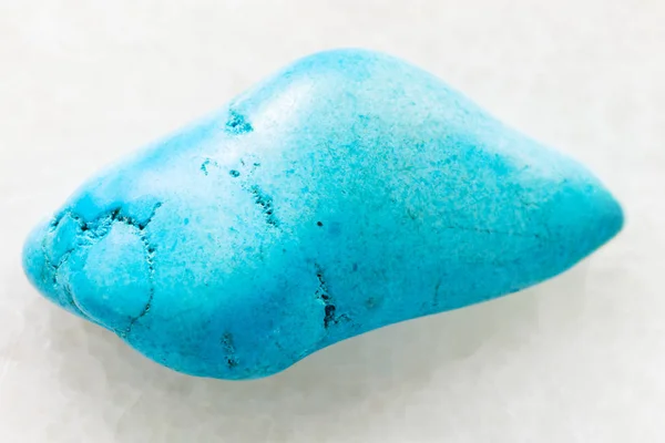 Tromlované gem Turquenite (modré howlite) na bílém pozadí — Stock fotografie