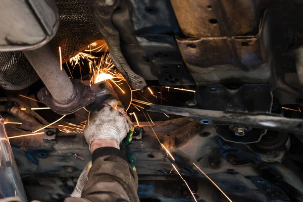 Mechanic cleans silencer pipe by angle grinder — Stock Photo, Image