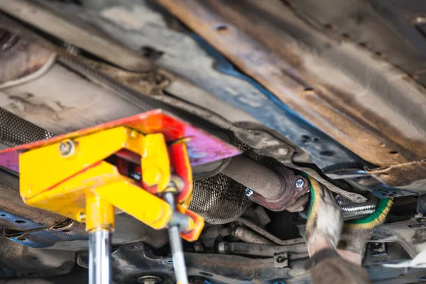 Mecânico corrige tubo silenciador no carro — Fotografia de Stock