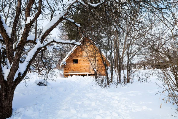 Domek dřevo v zasněžené zahradě — Stock fotografie