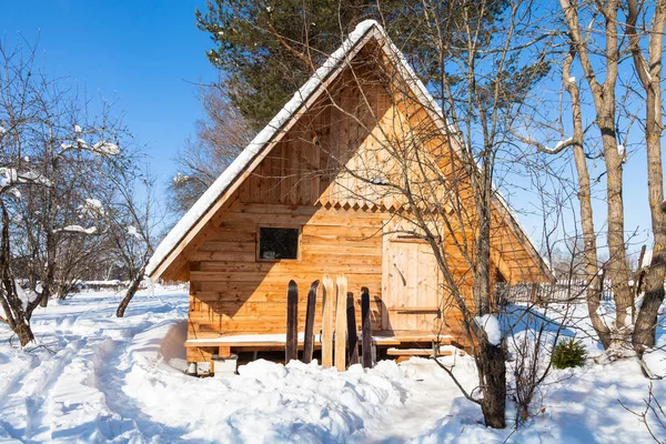 View of little timber cottage and wide skis — Stock Photo, Image