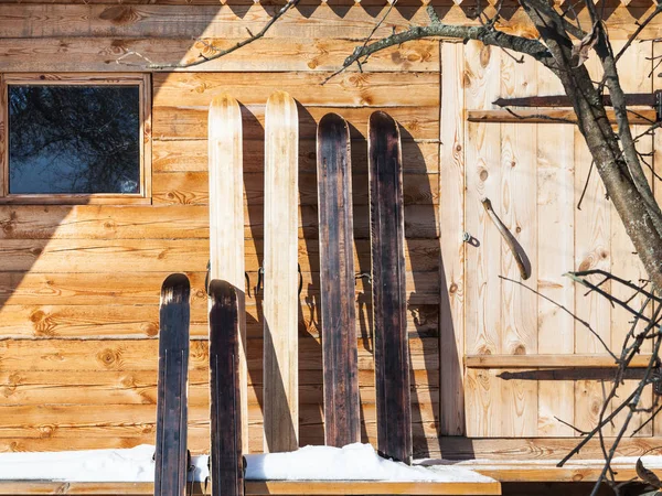 Wide hunting skis in front of wooden cottage — Stock Photo, Image