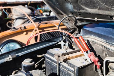 Jump starting old car battery with another vehicle clipart