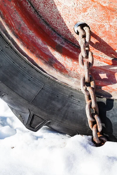 Cadena de nieve oxidada montada en la rueda del tractor —  Fotos de Stock