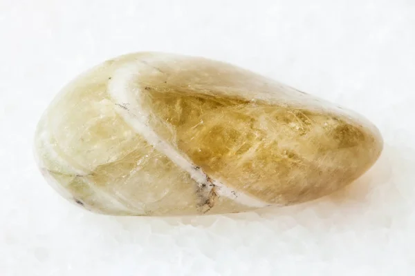 Камешек из прасиолита на белом камне — стоковое фото